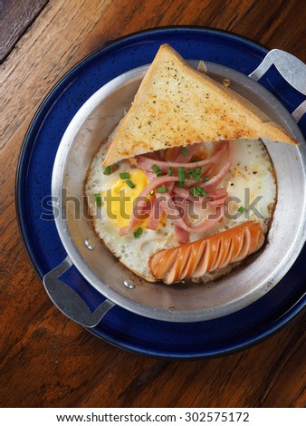Sunny Side Up eggwith sausage ham and garlic bread