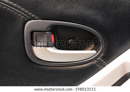 inside car door handle with lock on black leather