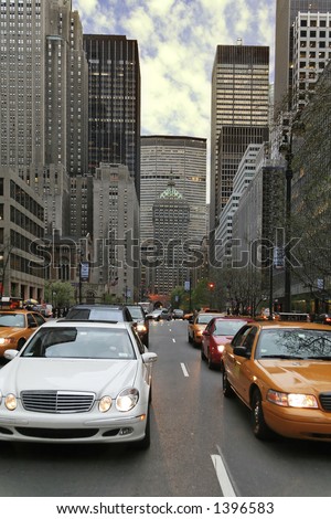 Busy street in a large city with skyscrapers and cars. Many yellow taxi-cabs.