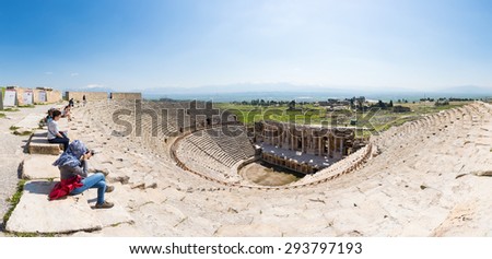 PAMUKKALE, TURKEY - April 16: Tourists watching the ancient theater of the Roman city of Hierapolis on April 16, 2014 in Pamukkale, Turkey. The site is a UNESCO World Heritage site