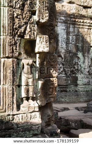 Apsara carved without head on the wall of ancient temple in Cambodia