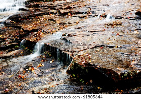 waterfall at fall time with stones and leaves