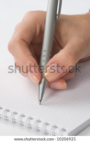 Blank notebook and a pen in a  woman\'s hand