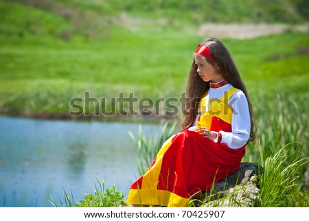 girl in traditional Russian dress at the lake