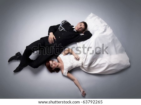 Romantic image of just married couple laying on the floor together and looking at each other