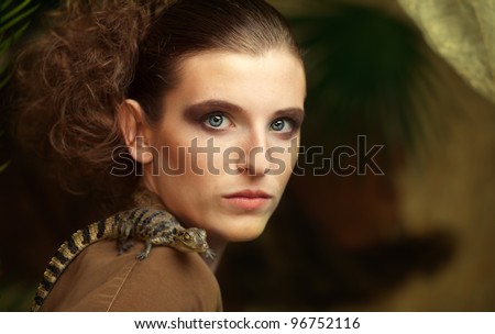 Blonde woman with cayman in jungle scenery