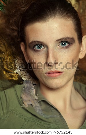 Blonde woman with leopard gecko in jungle scenery