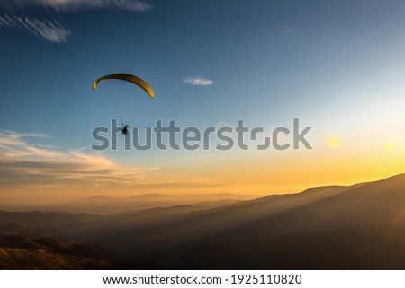 paraglider flies over the mountains at sunset Stock foto © 