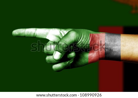 Human hand point with finger in Zambia national flag