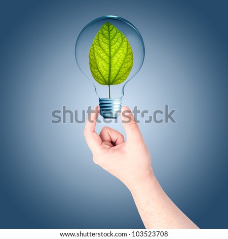 Man hand holding on light bulb with green plant inside. Concept for idea for environmental conservation