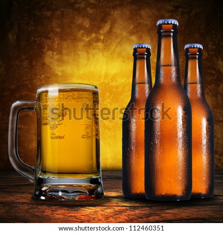 Close up of jug of beer and three beer bottles. Cold refreshment