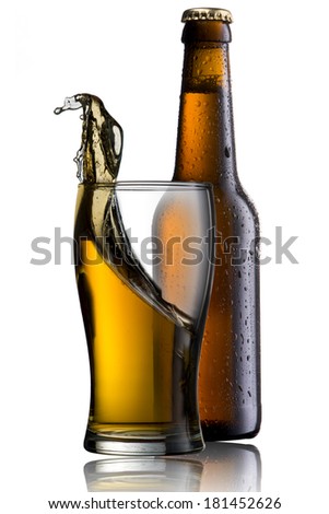Beer splash from glass with cold beer bottle