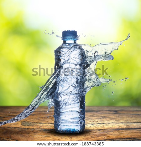 Water Splash on Water bottle on wood table and summer scene background