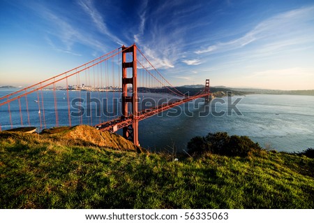 Golden Gate in clear blue sky with green grass as foreground. San Francisco, USA.