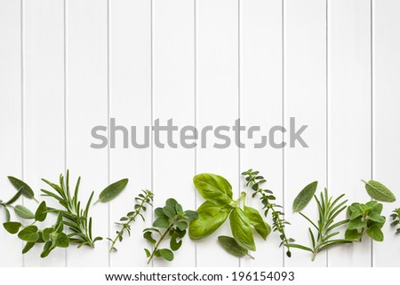 Fresh herbs border over white timber panel background.