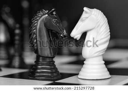 Chess knights head to head.  Black and white image.