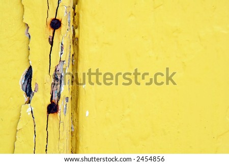 Aged yellow-painted timber, with rusted bolts.