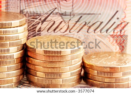 Australian coins ~ stacks of one dollar coins, with twenty dollar note behind.