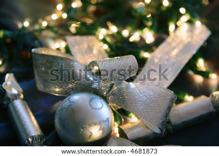 Christmas decorations ~ silver balls, ribbons and crackers, with fairy light background.