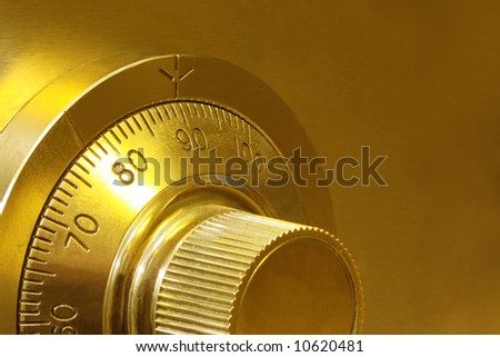 Golden toned combination safe lock, in close-up.