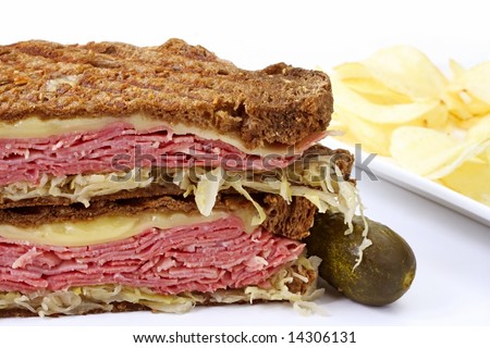 Traditional Reuben sandwich, with grilled rye bread, corned beef, melted Swiss cheese and sauerkraut.  Served with a pickle and potato chips.