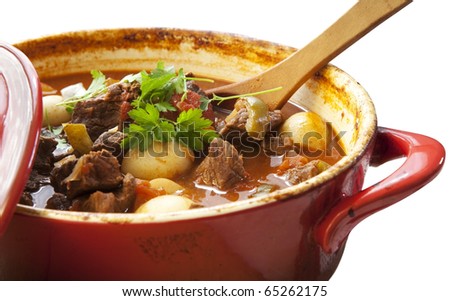 Beef stew in a red crock pot, ready to serve.