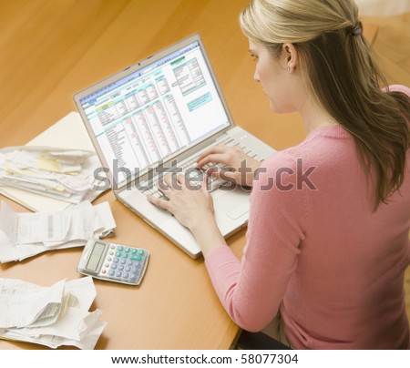 High angle view of a young woman using a laptop computer to organize her finances.  Horizontal shot.