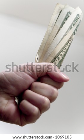 A hand grabbing a fistful of US twenty dollar bills
