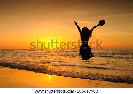 Woman jump on the beach at sunset