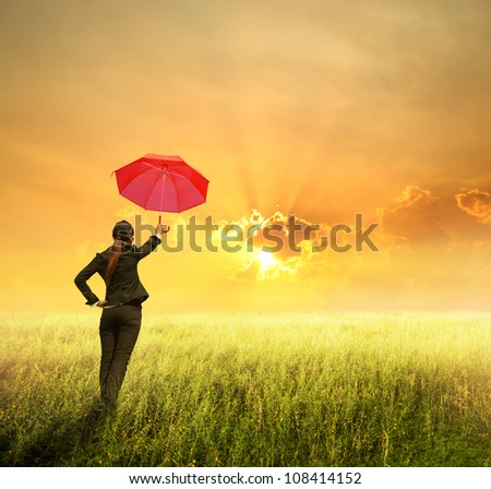 Business umbrella woman standing to sunset in grassland with red umbrella