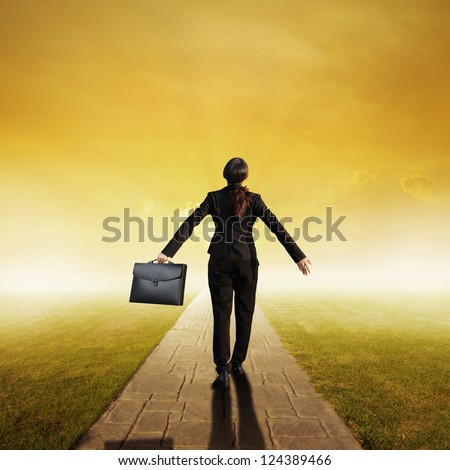 Relax business woman holding bag on Concrete road in Grass fields and sunset