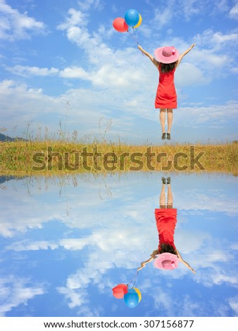 Water Reflection Happy Woman Jumping and holding balloons with blue sky.Copy space
