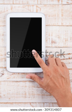 Man hand pointing tablet phone   on wood table background.Copy space