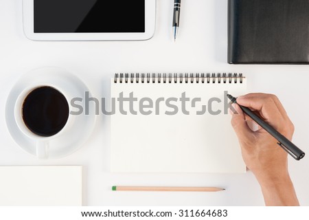 Cup of hot coffee tablet  phone and man hand writing notebook on  white background .copy space