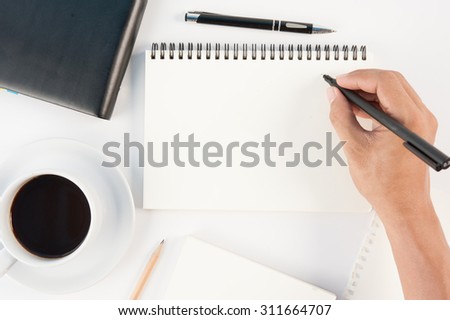 Cup of hot coffee tablet phone and man hand writing notebook on  white background .copy space