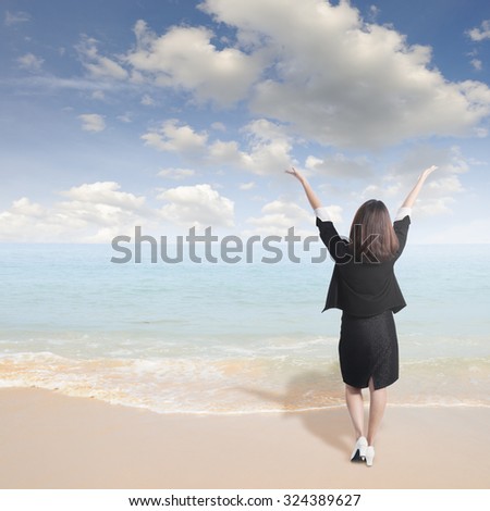 Asian business woman happy and standing on beach and sun sky.Vacation and holiday concept.