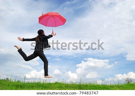 Business umbrella woman jumping to blue sky in grassland with red umbrella