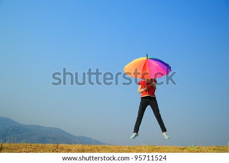 Multicolor umbrella woman jump to Blue sky