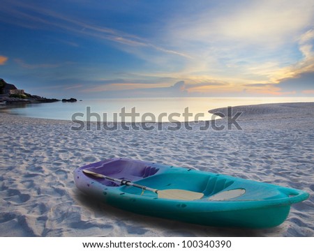 green sea kayak on sand beach