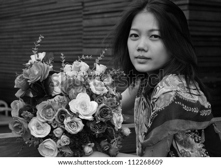 face of woman holding bouquet flower in black and white