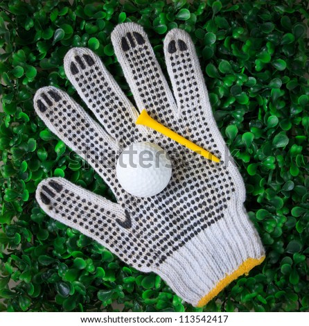 golf ball hand gloves and yellow tee