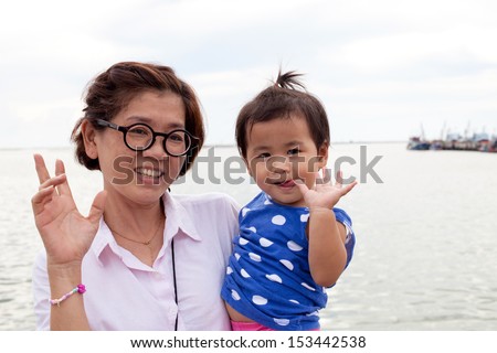 young grand mother holding her grandchild and smiling