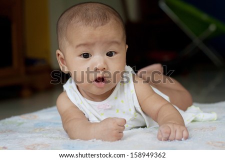 face of newborn baby lying on bed and open mouth wow