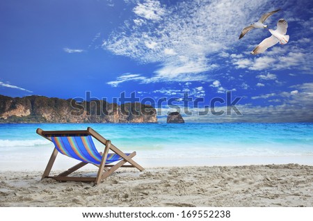 wood chairs beach at sea side with beautiful sea gull birds flying on blue sky and line stone island against ocean horizontal use as vacation and holiday natural background