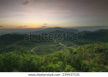 landscape scene of natural mountain and rural roads through the forest with sun rising in morning sky use as nature background,backdrop