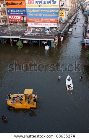 BANGKOK THAILAND - NOV 8 :people on the road construction vehicle navigating through the flood at soi Chokechai Ruammite Viphawadi Rd.on Nov 8 , 2011 in Bangkok Thailand
