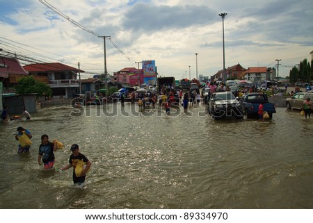 AYUTTHAYA THAILAND - OCT 14 : unidentified people  walking through flood water on Rojana Rd. on October 14,2011 in Ayutthaya Thailand
