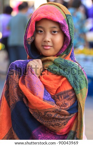 girl and colorful silk clothes cover her head