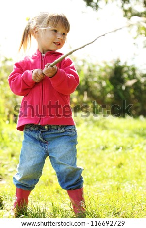 beautiful little girl with stick rod on nature