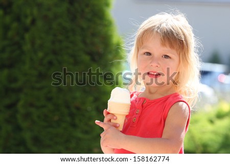 a little girl eating ice cream outdoors